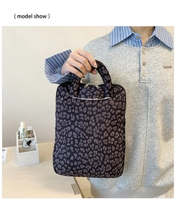 Detail of leopard print laptop bag with sturdy top handle and smooth metal zippers