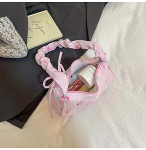 Detailed view of pink floral canvas bag with ruffled handle and drawstring closure
