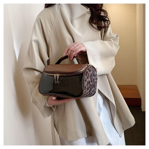 Detail of PU leather makeup bag with leopard print side and gold zipper closure