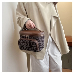 Detail of leopard print vanity case with faux suede texture and golden metal zippers