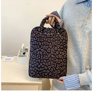Detail of grey leopard print laptop sleeve with knitted texture and round handles