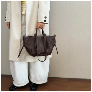 Detail of chocolate brown tote bag with white contrast stitching and tie design