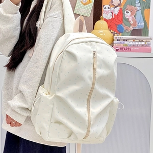 Detail of cream canvas backpack with blue star patterns and side drawstring pockets