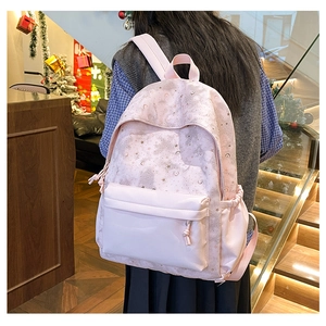 Pink student backpack with silver moon and star patterns and padded shoulder straps