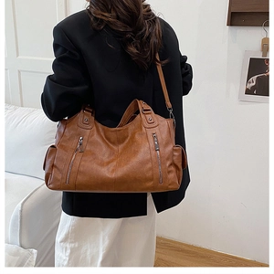 Detail view of brown vintage leather tote bag showing large capacity and multi-pocket texture