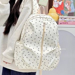 Detail view of white canvas backpack with star print featuring side pockets and drawstring