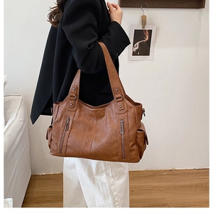Caramel faux leather tote bag shown on shoulder in a lifestyle home setting for daily use