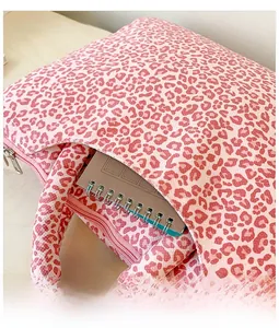 Detail of pink leopard print tote bag with a front pocket holding a spiral notebook
