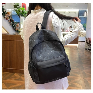 Detailed side view of black backpack with starry print and drawstring side pocket