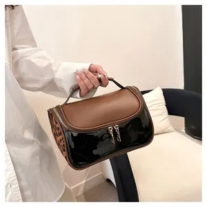 Detail of PU leather makeup bag with double zippers and leopard print side panel in use