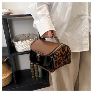 Detail of multi-material vanity bag featuring leopard print and double metal zippers