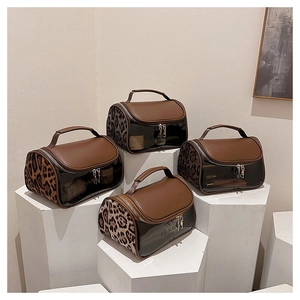 Detail view of double-layer travel toiletry bag with leopard print and clear PVC panel