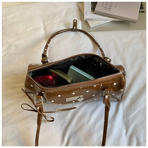 Overhead view of a retro brown polka dot handbag with bow strap and inner storage