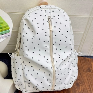 White canvas backpack with black stars and music notes print for school or travel