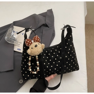 Black and white polka dot hobo bag with a cute plush bear pendant and double straps