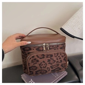 Leopard print makeup bag with faux suede texture and brown leather handle for travel