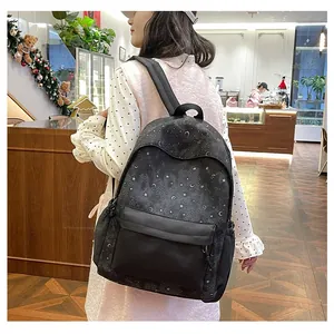 Lifestyle view of a black star and moon print backpack being worn in a cafe setting