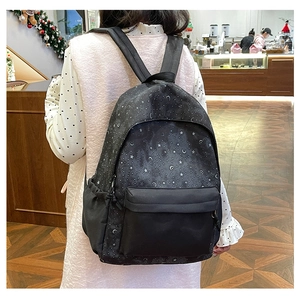 Starry sky pattern backpack showing large main compartment and front pocket worn by model