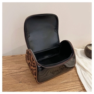 Top view of open leopard print toiletry bag with black lining and dual texture design