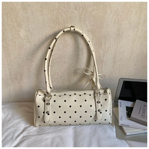 Chic cream Boston bag with black polka dots and silver studs on minimalist background
