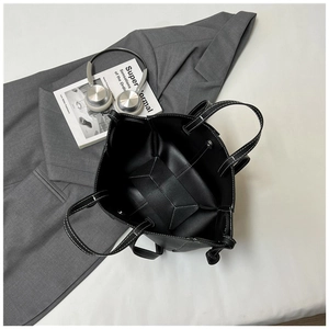 Detail of black pebbled leather tote with contrasting white stitching and spacious interior