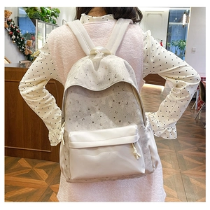 Detail of the moon and star prints on the cream white faux leather casual backpack