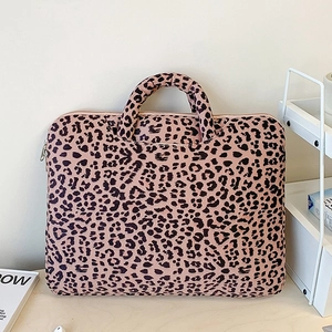 Minimalist leopard print laptop tote bag with sturdy handles on a wooden table