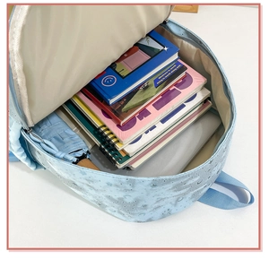 Detail of blue student backpack showing large capacity for books and tablet