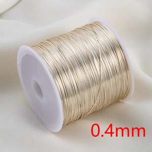 Detail of 0.4mm champagne gold copper wire on a white spool for DIY jewelry making