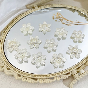 Macro-opname van parelwitte bloemvormige kralen op een decoratieve spiegelwand
