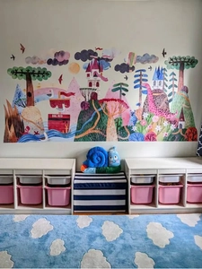 Détail du sticker mural avec montagnes roses, châteaux et motifs animaux variés