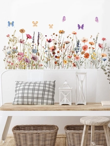 Vue détaillée des stickers muraux fleurs sauvages et papillons sur un mur blanc pur