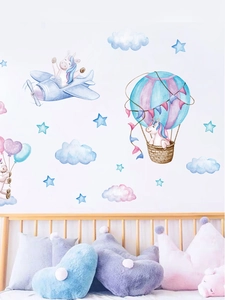 Unicorn wall stickers with planes and balloons on a white wall in a nursery setting