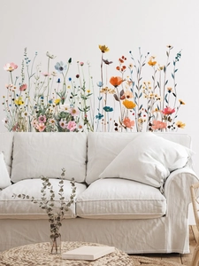 Vue détaillée d'un sticker mural fleurs sauvages à l'aquarelle posé derrière un canapé