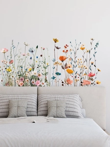 Décoration murale de chambre avec des stickers de fleurs sauvages sur un lit gris
