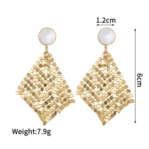Macro view of geometric gold earrings with pearl studs and measurement details