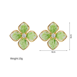 Detailed view of french vintage floral studs with white enamel and green texture details