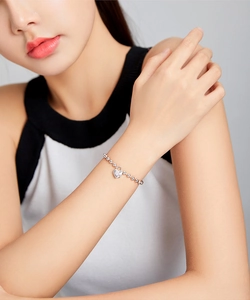 Detail eines s925 Silberperlenarmbandes mit Herz-Vorhängeschloss-Anhänger am Handgelenk