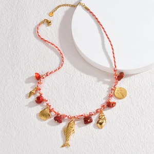 Bohemian style orange braided rope necklace with red stones and gold sea charms