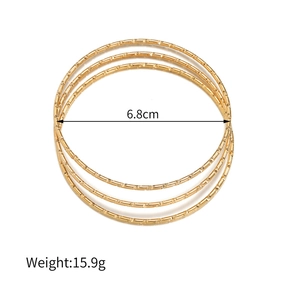Detailopname van vier gouden armbanden met gekartelde textuur en diameter van 6,8 cm