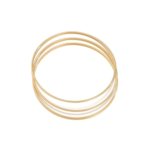 Detailweergave van drie gepolijste gouden geometrische ronde armbanden in een minimalistisch design
