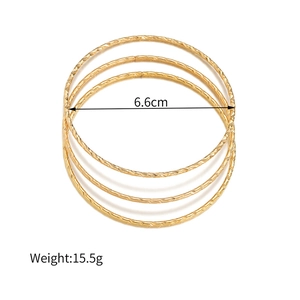 Detail van vier gouden armbanden met gehamerde textuur en 6,6 cm binnendiameter