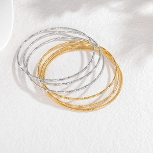 Set van zes minimalistische armbanden met getextureerde sterrengravure in goud en zilver