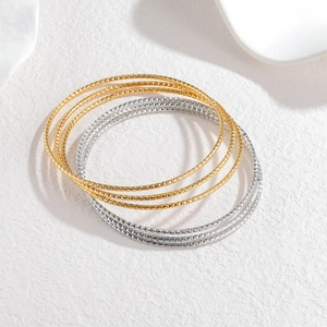 Gouden en zilveren geometrische armbandset met elegante ruitvormige textuurdetails
