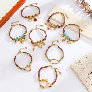 Close-up of bohemian hand-woven bracelets with 18k gold heart charms and turquoise beads