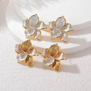 Pendientes de flores bañados en oro de 18k con textura detallada y acabado tricolor