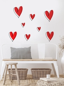 Detail of red heart wall stickers arranged on a modern minimalist white living room wall
