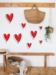 Detail showing various sizes of red heart wall decals arranged in a cozy bedroom setting