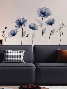 Détail de stickers muraux pavot bleu appliqués derrière un canapé gris moderne