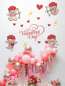 Detail of Cupid heart stickers and Valentine's Day text on a white brick wall